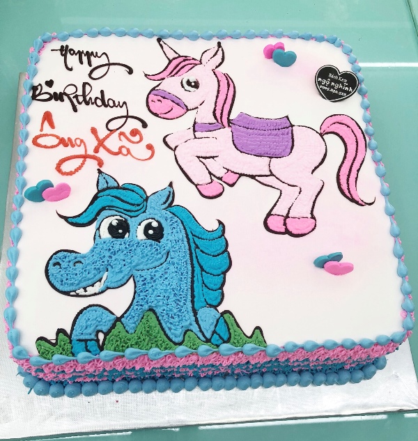 Bánh sinh nhật với hình con ngựa đáng yêu và màu sắc tươi sáng, đặc biệt là màu hồng và màu xanh, được thiết kế và trang trí tỉ mỉ để tạo ra một bữa tiệc sinh nhật đáng nhớ. Hãy xem hình để cảm nhận được sự đẹp mắt và ngọt ngào của bánh này.